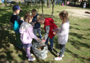 Dzieci wrzucają śmieci do worka
